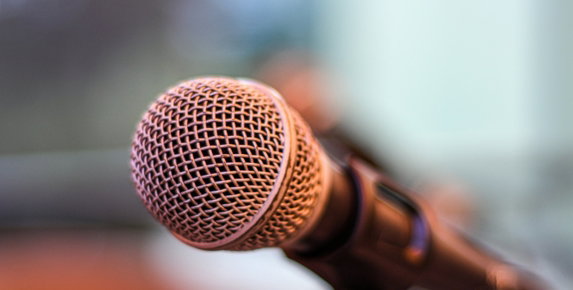 grey microphone on brown wooden stand